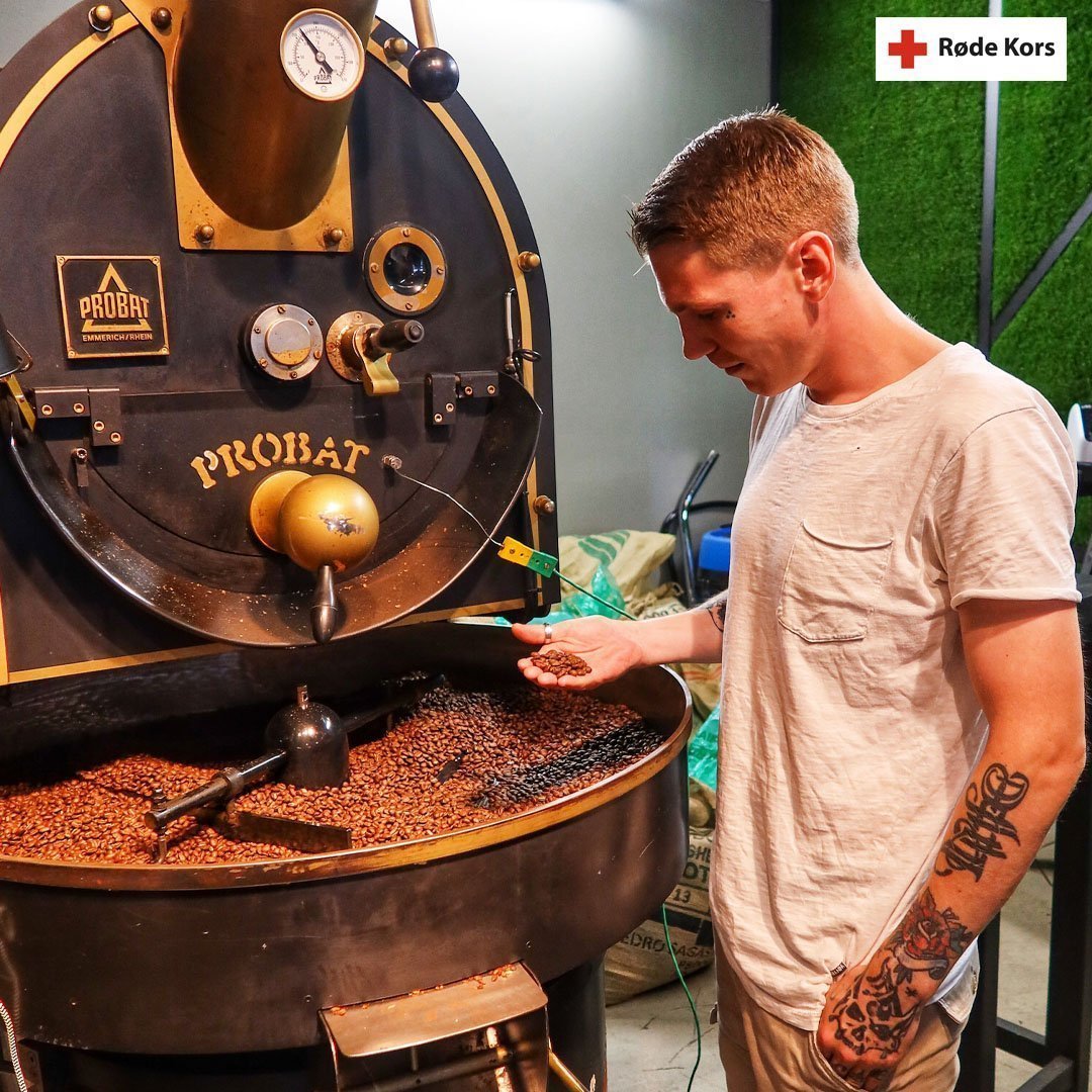 Tattovert mann holder kaffebønner